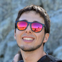 Photo portrait de David avec des lunettes de soleil, en montagne